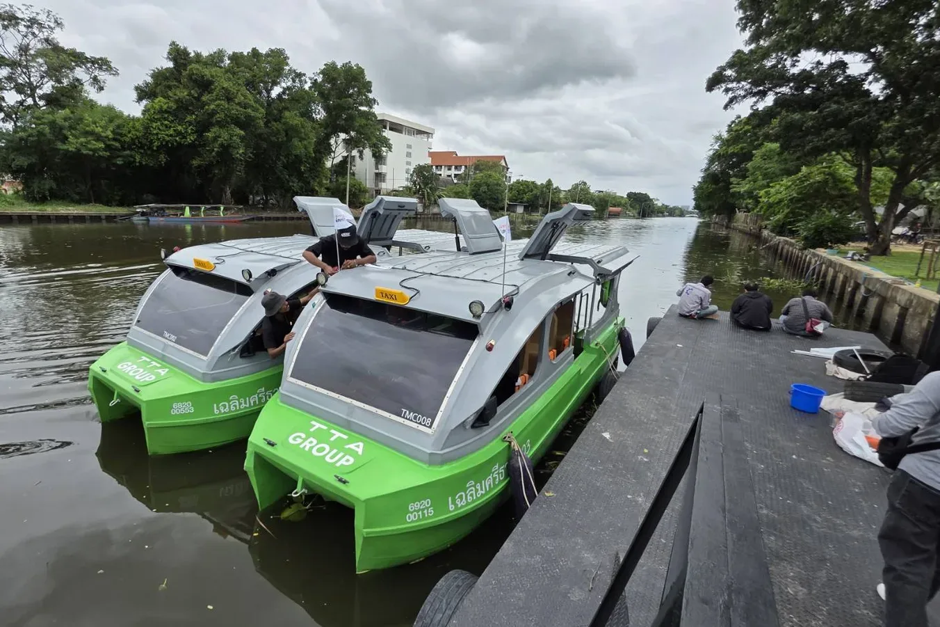 เรือไฟฟ้าสีเขียวของ TTA Group สองลำ หมายเลขเรือ TMC002 และ TMC008 จอดอยู่ที่งานทดลองรถไฟ-เรือของ KMITL Expo