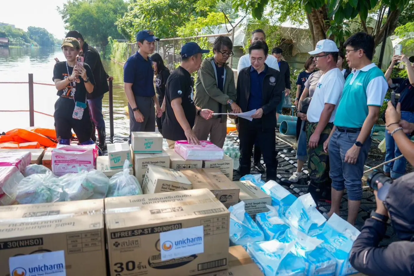 กล่องสิ่งของบรรเทาทุกข์ที่จุดส่งมอบริมน้ำ พร้อมเจ้าหน้าที่